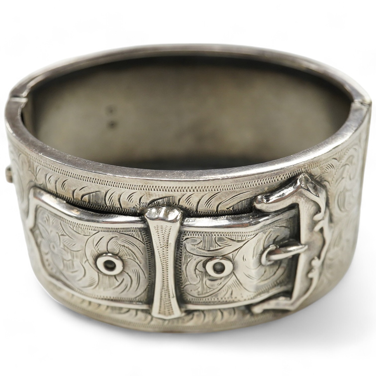 A George V engraved silver hinged bangle, with 'buckle' decoration, Kirwan & Co Ltd, Birmingham, 1913. Condition - poor to fair